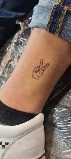 a person's foot with a small tattoo on their left ankle and the word peace written