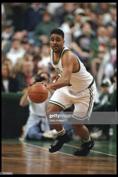 a basketball player dribbling the ball during a game in front of an audience