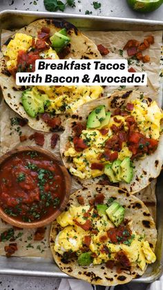 breakfast tacos with eggs, avocado and salsa on a sheet of parchment paper