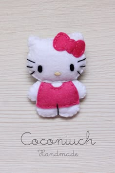 a hello kitty brooch sitting on top of a wooden table