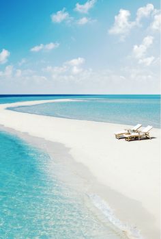 an empty beach with lounge chairs on it