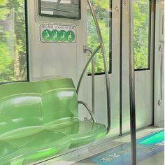 the interior of a subway train with green seats and trees in the backround