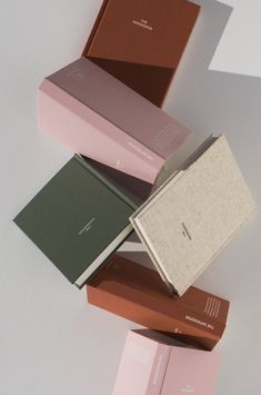 five books stacked on top of each other in different colors and sizes, with the covers folded down