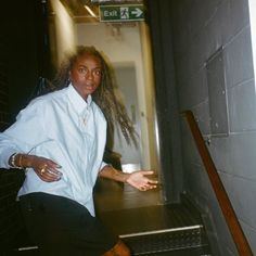 a woman standing in an elevator with her hand out