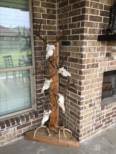 a metal deer head mounted to the side of a brick wall next to a window