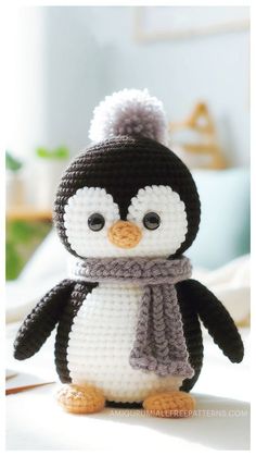 a crocheted penguin wearing a scarf and hat