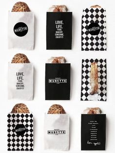 six black and white paper bags with different types of bread in them on a white surface