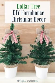 two potted christmas trees sitting on top of a white shelf next to a sign