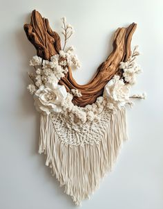 a piece of art that has flowers and branches on it, hanging from the wall