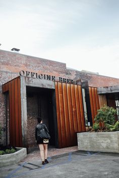 a woman walking out of an open brick building