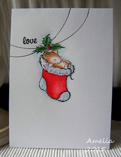 a christmas card with a teddy bear in a stocking hanging from it's side