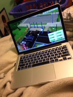 an open laptop computer sitting on top of a bed