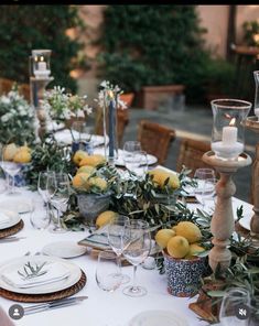 the table is set with lemons and greenery