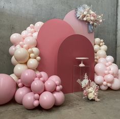 balloons and flowers on display in front of a wall