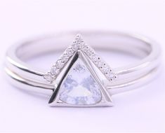 a white gold ring with a triangle shaped diamond