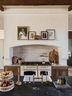 a kitchen with an oven, sink and pictures on the wall