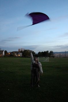 a woman is flying a kite in the evening