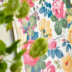 a flowered wallpaper with pink, yellow and green flowers on it's side