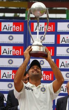 a man holding up a trophy in front of him