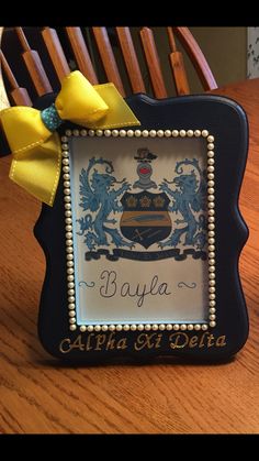 a wooden table topped with a blue and white frame filled with an ornate coat of arms