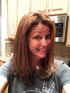 a woman with long hair is smiling in the kitchen