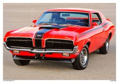 an old red muscle car with black stripes on it's hood parked in a parking lot