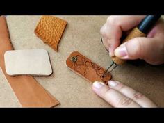 a person is cutting leather with a pair of scissors and a piece of paper on the table