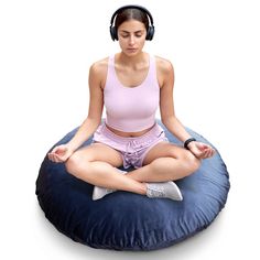 a woman is sitting on a bean bag chair and listening to music with headphones