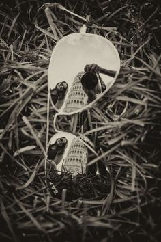 two birds are reflected in the mirror of a pair of sunglasses sitting on some grass