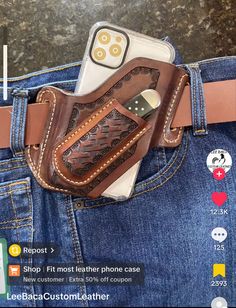 a cell phone in a leather case on the back of a pair of blue jeans