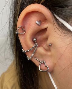 a woman wearing ear piercings with hearts on them