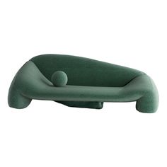 a green couch with a ball on it's back and arms in the shape of a reclining chair