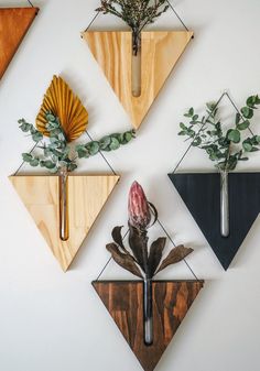 four wooden wall hangings with flowers and plants on them