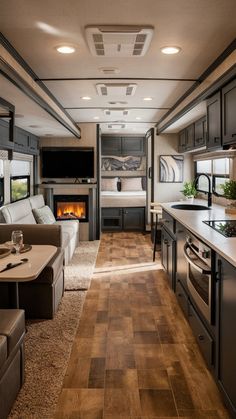 the interior of a recreational vehicle with wood flooring and couches in front of an open fire place