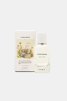 a bottle of cologne sitting next to a box on a white surface with an image of flowers