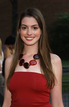 a woman in a red dress smiling at the camera