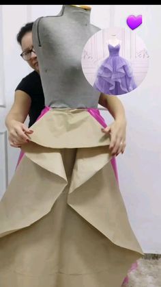 a woman in a dress made out of paper and cardboard with the skirt folded down