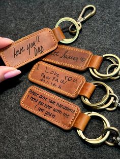 three leather keychains with handwritten words on them, one is for dad and the other is for daughter