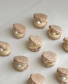 several cookies with white frosting and macaroni shells on a sheet of paper