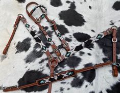 two brown and white horses bridles on a black and white cow print background