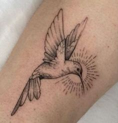 a small bird with sunburst tattoo on it's leg and the word love is