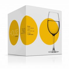 a wine glass sitting in front of a white box with yellow circles on the side