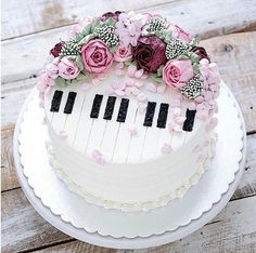 a cake decorated with flowers and piano keys