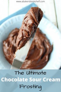 the ultimate chocolate sour cream frosting recipe is in a bowl with a spatula