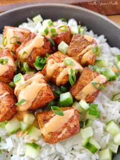 a bowl filled with rice and meat covered in sauce