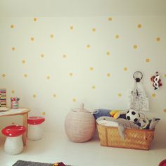 a child's room with yellow polka dots on the wall and toys in baskets