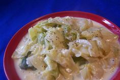 a red plate topped with pasta and cheese