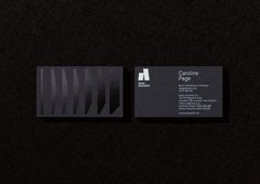 two business cards sitting side by side on top of a black surface with white lines