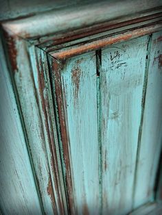 an old wooden cabinet with peeling paint on the top and bottom part, in blue