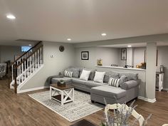 a living room filled with furniture and a stair case